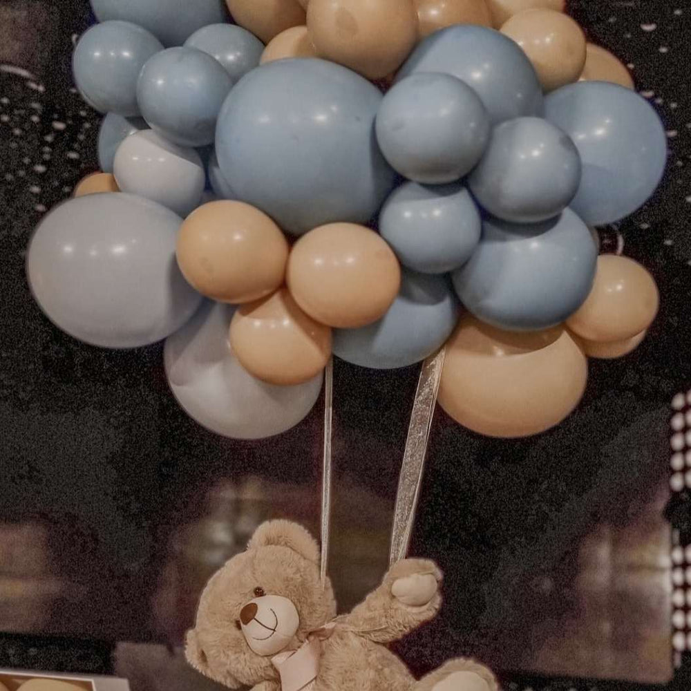 
                  
                    norisori din baloane de heliu, legat de un ursulet de plus cu o panglica aurie
                  
                